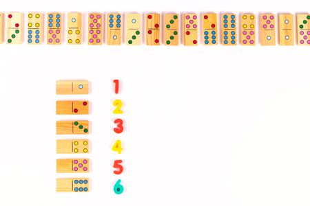 Colored dominoes and numbers on a white background. Learning mathematics of children at school, preschool,kindergarten. Educational concept. Flat lay. Copy spaceの写真素材