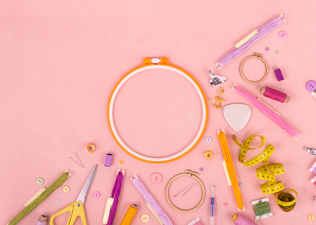 Embroidery and cross stitch accessories on pink background. Flat lay. Copy spaceの写真素材