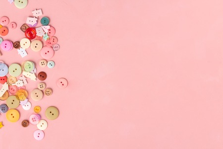 Colorful buttons on pink background. Flat lay, sewing concept.の写真素材