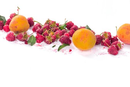 Fresh organic raspberries and apricot. Fruit background on white. Summer fruits and berries harvest...