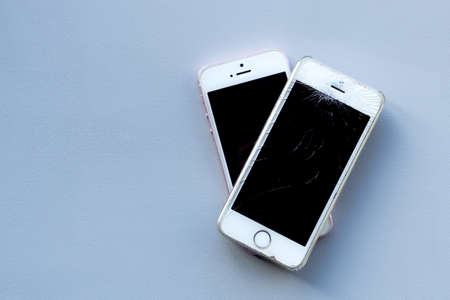 Broken glass screen smartphone. Work of service center showing smartphone while using protection...
