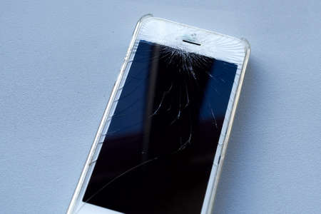 Broken glass screen smartphone. Work of service center showing smartphone while using protection...