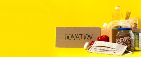 Banner.Donation. Food supplies crisis food stock for quarantine isolation period on yellow background. Rice, peas, cereals, canned food, oil, vegetables, mask, sanitizer. Food delivery. Cope space.の写真素材