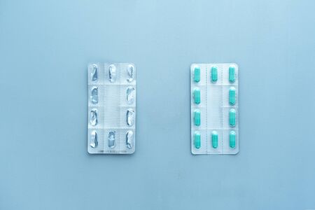 Empty vs full blisters from tablets on a blue background. Medical, environmental concept. Health therapy. Pandemic, epidemic, vaccination.の写真素材