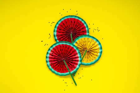 Paper fruit origami watermelon fan decoration top view on bright yellow background. Tropics summer