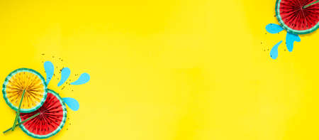 Paper fruit origami watermelon fan decoration. Creative banner with copy space on bright yellow background. Tropics summerの写真素材