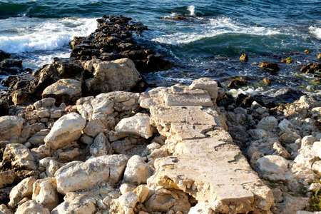 outdoor on the seashore on the sand among large beautiful yellow stonesの写真素材