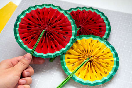 DIY instruction. Step by step tutorial. Making decor for summer birthday party - red and yellow watermelon fan. Craft tools and supplies. Step 8 - Finalの写真素材