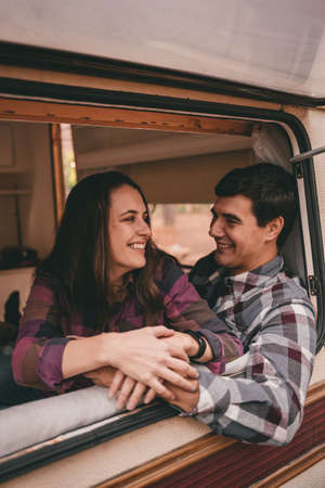 Happy family on a camping trip relaxing in the autumn forest. Camper trailer. Fall season outdoors tripの写真素材