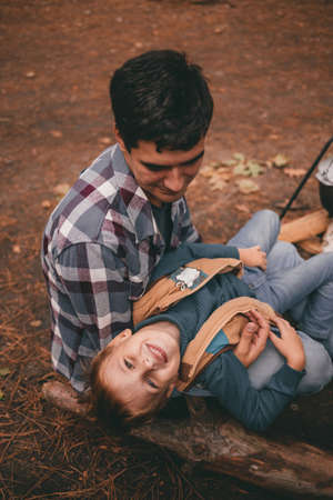 Father and son on a camping trip relaxing in the autumn forest. Camper trailer. Fall season outdoors...