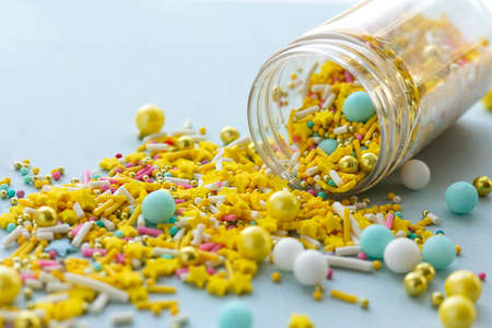 Yellow sugar sprinkles grainy on blue background, close-up
