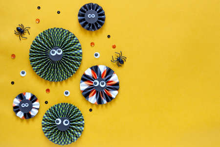 Happy halloween holiday concept. DIY paper decorations on bright yellow background. Halloween party greeting card mockup with copy space. Flat lay, top view, overhead bannerの写真素材