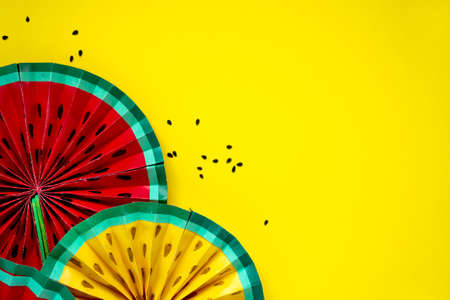 Paper fruit origami watermelon fan decoration. Creative banner with copy space on bright yellow background. Tropics summerの写真素材