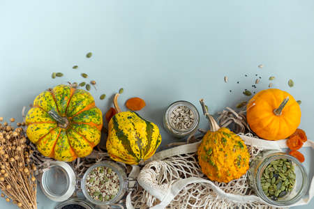 Zero waste healthy food pumpkin, seeds, vegetables, dried fruits flat lay on blue background. Groceries in textile bags,glass jars. Eco friendly plastic free low waste lifestyle.の写真素材