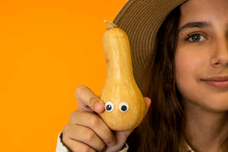 Girls hands hold pumpkins with eyes Fall seasonの写真素材
