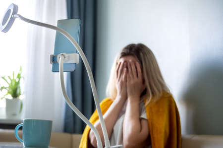 Woman experiencing fear before going live streamの写真素材