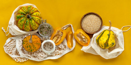 Zero waste healthy food pumpkin, seeds, vegetables, dried fruits flat lay on orange background. Groceries in textile bags,glass jars. Eco friendly plastic free low waste lifestyle.の写真素材
