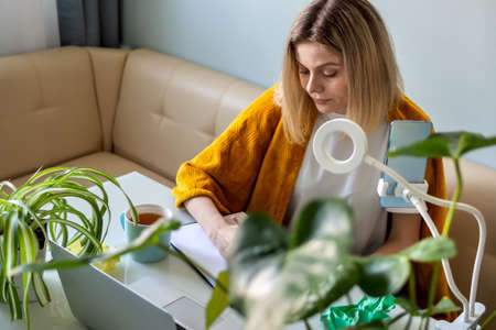 Blonde Woman distance work at home officeの写真素材