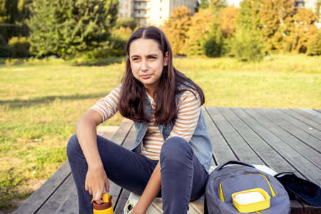 Teen girl student eating her lunch drinking waterの写真素材