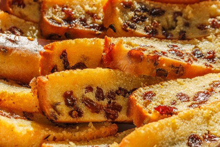 Freshly baked and sliced sponge fruit cake with raisins on plateの写真素材