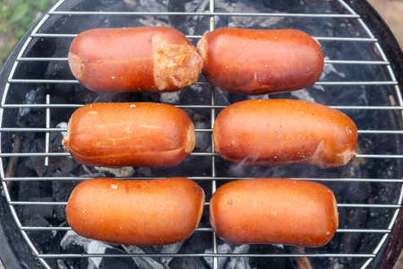 Close up barbecue grill with meat and sausages cooking during summer garden partyの写真素材