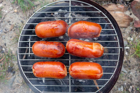 Close up barbecue grill with meat and sausages cooking during summer garden partyの写真素材
