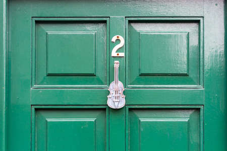 House number 2 on a green wooden front door with violinの写真素材