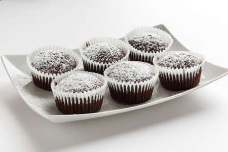 Several chocolate muffins on the white square plate. Shallow focus.の写真素材