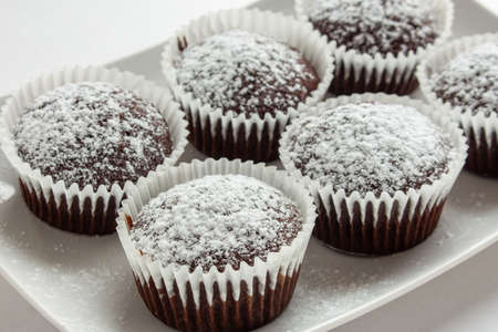 Several chocolate muffins on the white square plate. Shallow focus.の写真素材