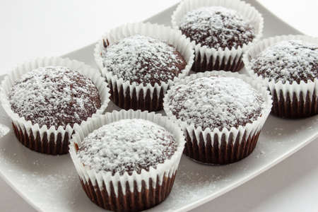 Several chocolate muffins on the white square plate. Shallow focus.の写真素材
