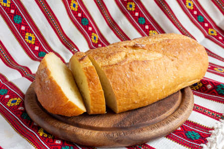 white bread on brown wood cutting board with sliced pieces of breadの写真素材