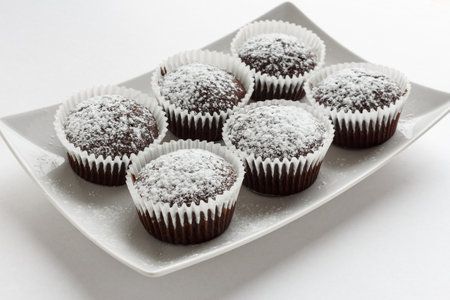 Several chocolate muffins on the white square plate. Shallow focus.の写真素材