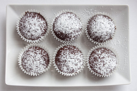 Several chocolate muffins on the white square plate. Shallow focus. Top view.の写真素材