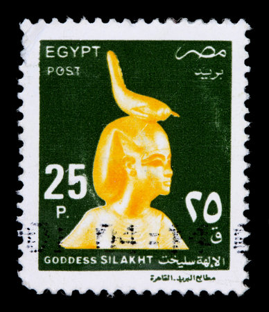 EGYPT - CIRCA 2000: A 25-piastre stamp printed in Egypt shows a golden statue of the Goddess Silakht with a bird on the head, circa 2000のeditorial素材