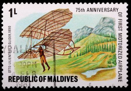 REPUBLIC OF MALDIVES - CIRCA 1981: A 1-laari stamp printed in the Republic of Maldives shows a man in Otto Lillenthal's glider, 1890, flying near a mountain range to commemorate the 75th anniversary of the first motorized airplane, circa 1981のeditorial素材