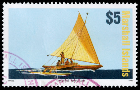 REPUBLIC OF THE MARSHALL ISLANDS - CIRCA 1994: A 5-dollar stamp printed in the Republic of the Marshall Islands shows islanders on a sailing canoe, circa 1994のeditorial素材