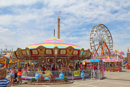 INDIANAPOLIS, INDIANA - AUGUST 12: The ferris wheel and carousel rides on the Midway at the Indiana State Fair on August 12, 2012. This very popular fair hosts more than 850,000 people every August.のeditorial素材