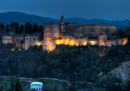 HDR image of part of the Alhambra palaces and fortifications against the mountains of Granada, Spain at duskのeditorial素材