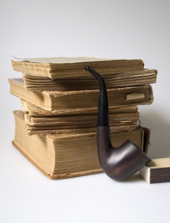 Stack of old books and a pipe の写真素材