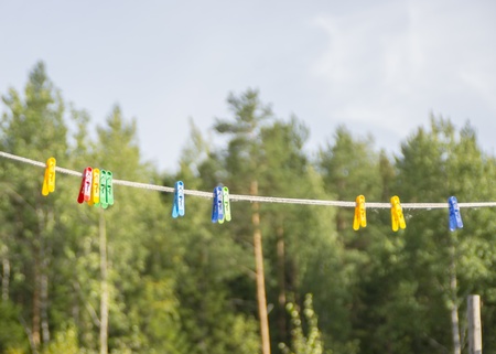 Clothespins on a rope in the forestの写真素材