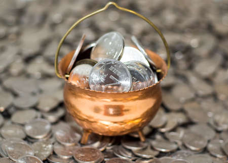 Pot with coins on coinsの写真素材