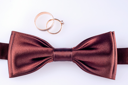 Bow tie and gold wedding ringsの写真素材