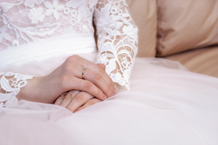 Hands of the bride in white and pink wedding dressの写真素材