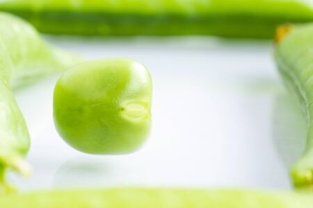 Concept of organic food ingredient - green pea in frame of pea pods