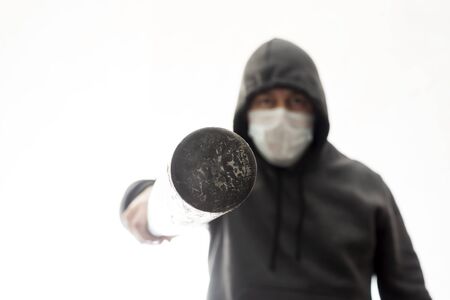 Aggressive man in hoodie pokes in face with baseball batの写真素材