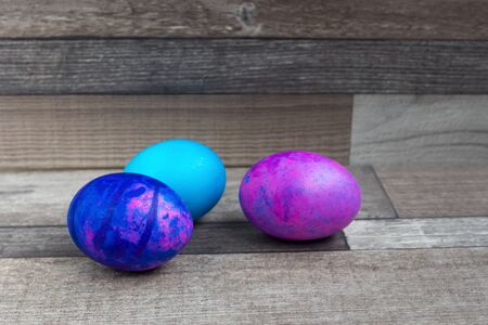 Vivid and bright easter eggs on the wooden background