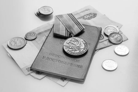 Labor veteran medal and pensioner's certificate on ruble cash, black and whiteの写真素材