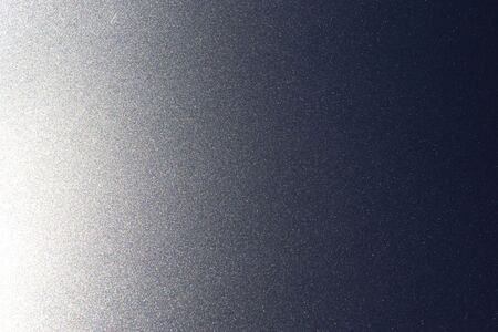 Shimmers on surface of metallic gray lacquered and polished metal background