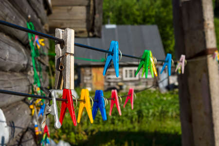 Clothespins on clothesline in village on background of old wooden country hut