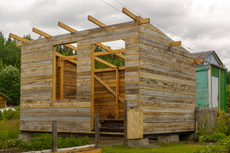 Wooden frame of a rustic barn under construction on village